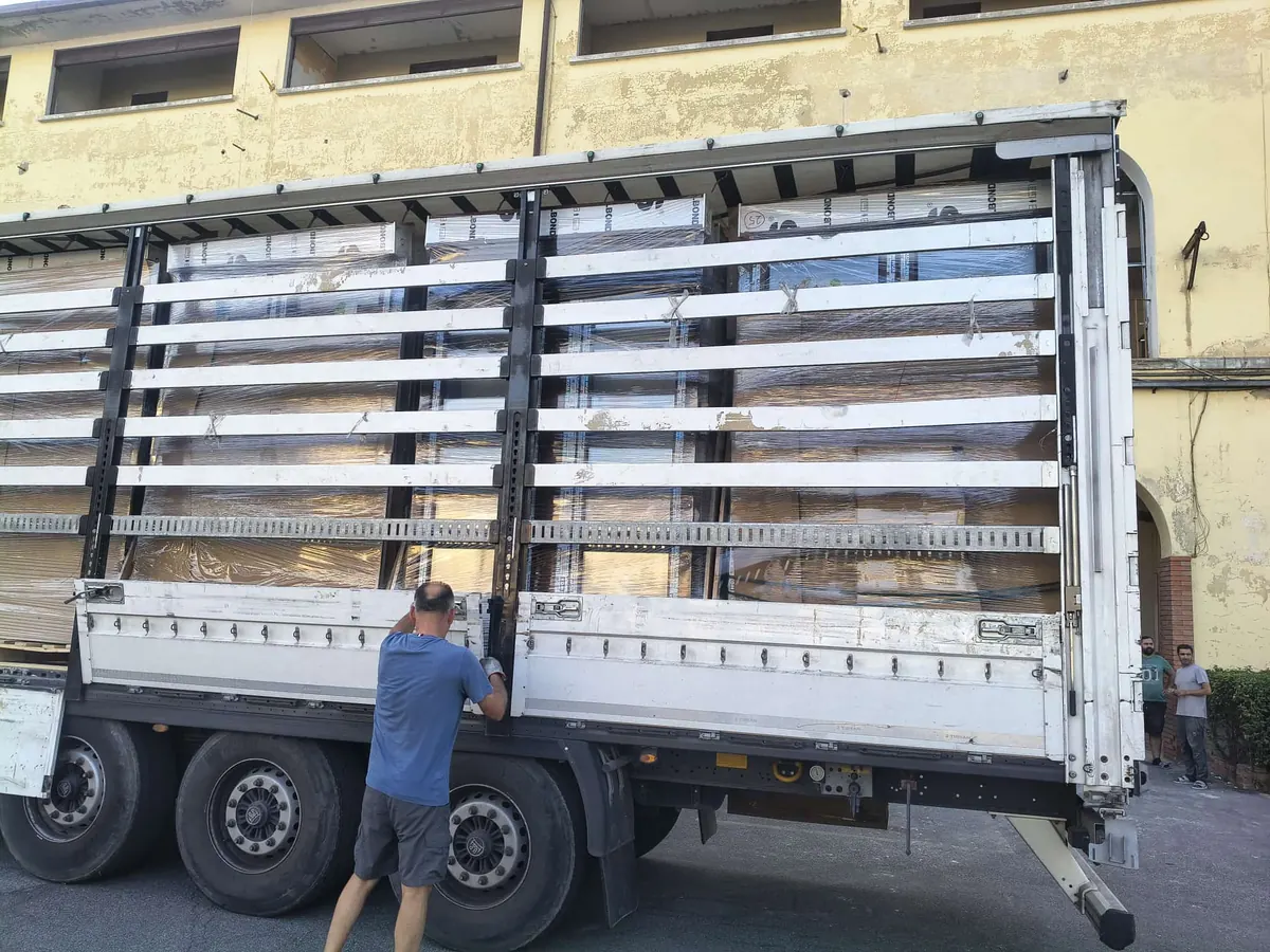 Scarico di un camion carico di serramenti imballati davanti alla sede